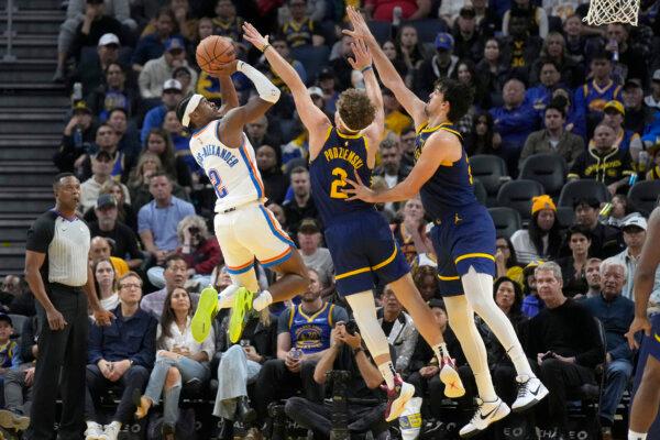 Oklahoma City Thunder guard Shai Gilgeous-Alexander scores over two Golden State Warriors during an NBA game in San Francisco on Nov. 18, 2023. (Jeff Chiu/AP Photo)