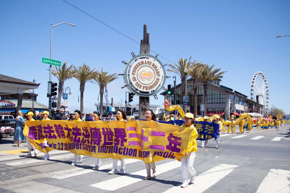 Practitioners hold banners and a golden dragon in the parade on May 11, 2024. (Lear Zhou/The Epoch Times)