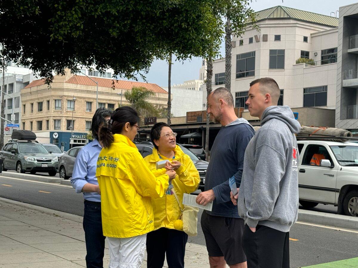 People stop to ask about the 25th celebration of Falun Dafa Day in Santa Monica, Calif., on May 12, 2024. (Linda Jiang/The Epoch Times)