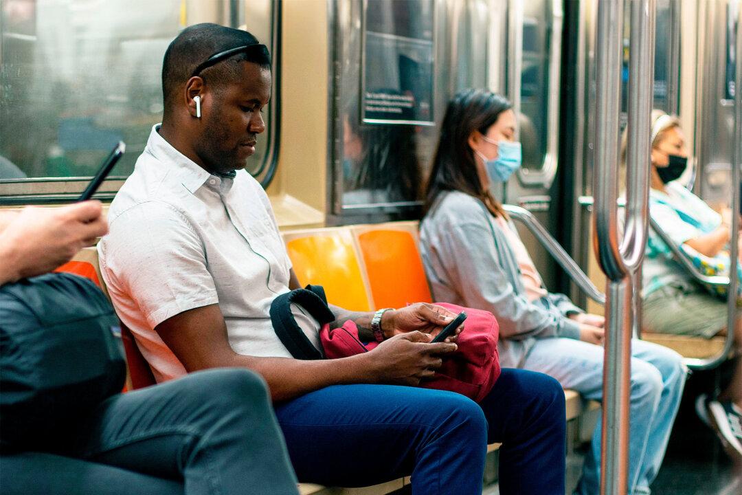 Passengers use their mobile phones on a subway train in New York City. (Tada Images/Shutterstock)