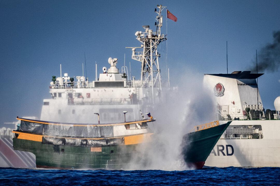 A Chinese Coast Guard ship fires a water cannon at a Philippine Navy chartered vessel that's conducting a routine resupply mission to troops stationed at Second Thomas Shoal, in the South China Sea on March 5, 2024. (Ezra Acayan/Getty Images)