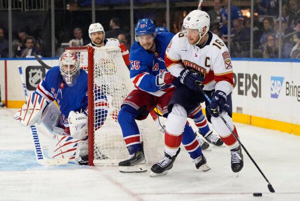Panthers center Aleksander Barkov (R) looks to pass the puck against Rangers defenseman Ryan Lindgren during Game 1 of the NHL Eastern Conference final in New York on May 22, 2024. (Julia Nikhinson/AP Photo)