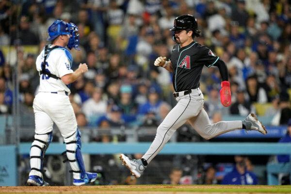 Corbin Carroll of the Diamondbacks scores on a wild pitch as Dodgers catcher Will Smith looks on in Los Angeles on May 22, 2024. (Mark J. Terrill/AP Photo)