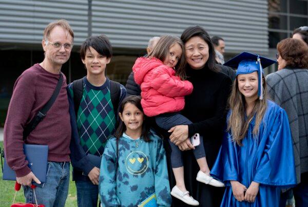 Athena Elling (R) posts for a photo with her family after attending the Irvine Valley College Commencement in Irvine, Calif., on May 23, 2024. (Sophie Li/The Epoch Times)