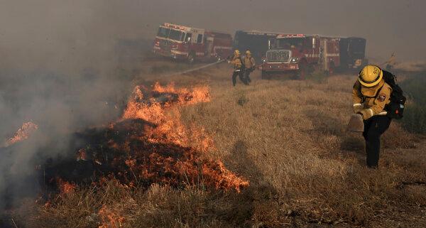 A Santa Clara Cal Fire crew scrambles to extinguish a spot fire in the median of Interstate 580, during the Corral Fire west of Tracy, Calif., on June 1, 2024. (Kent Porter/The Press Democrat via AP)