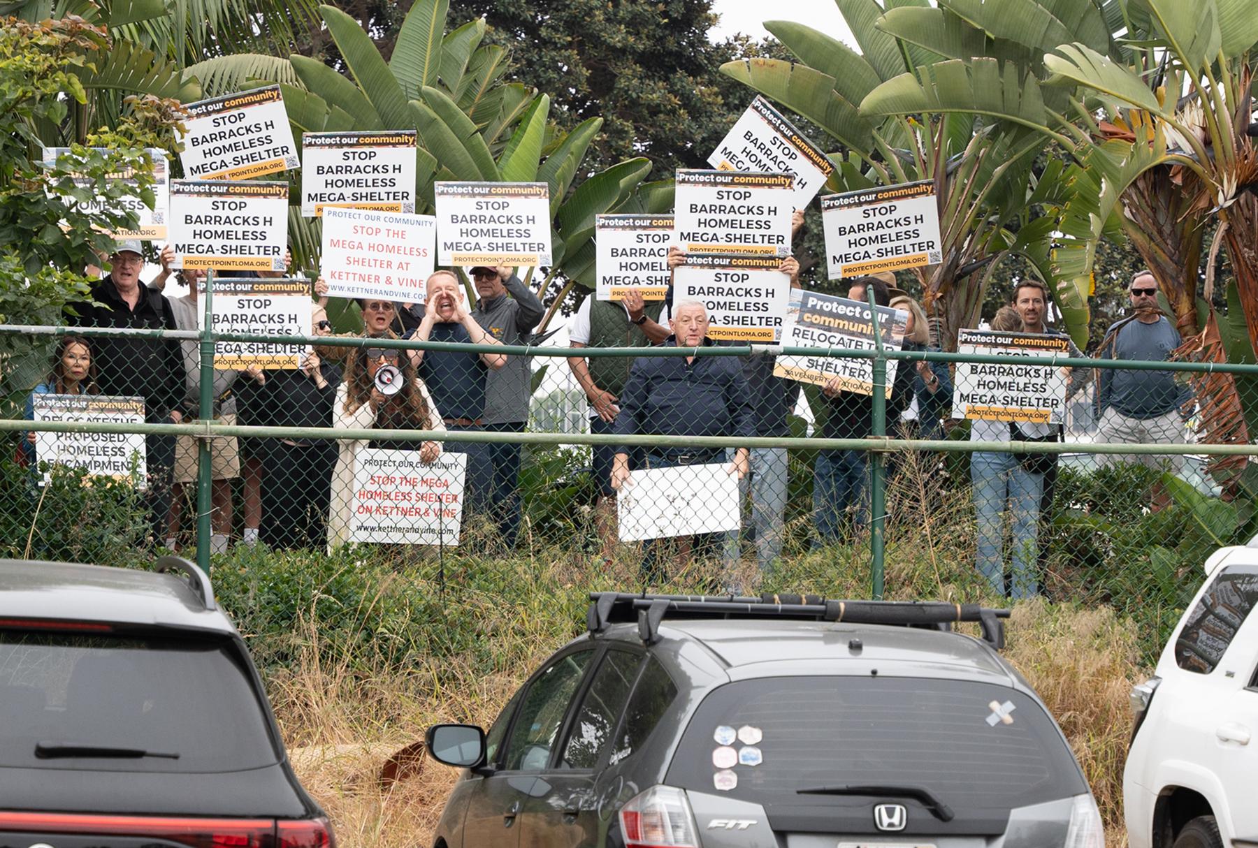 Protesters stand outside the H Barracks site during the mayor's press conference. (Jane Yang/The Epoch Times)