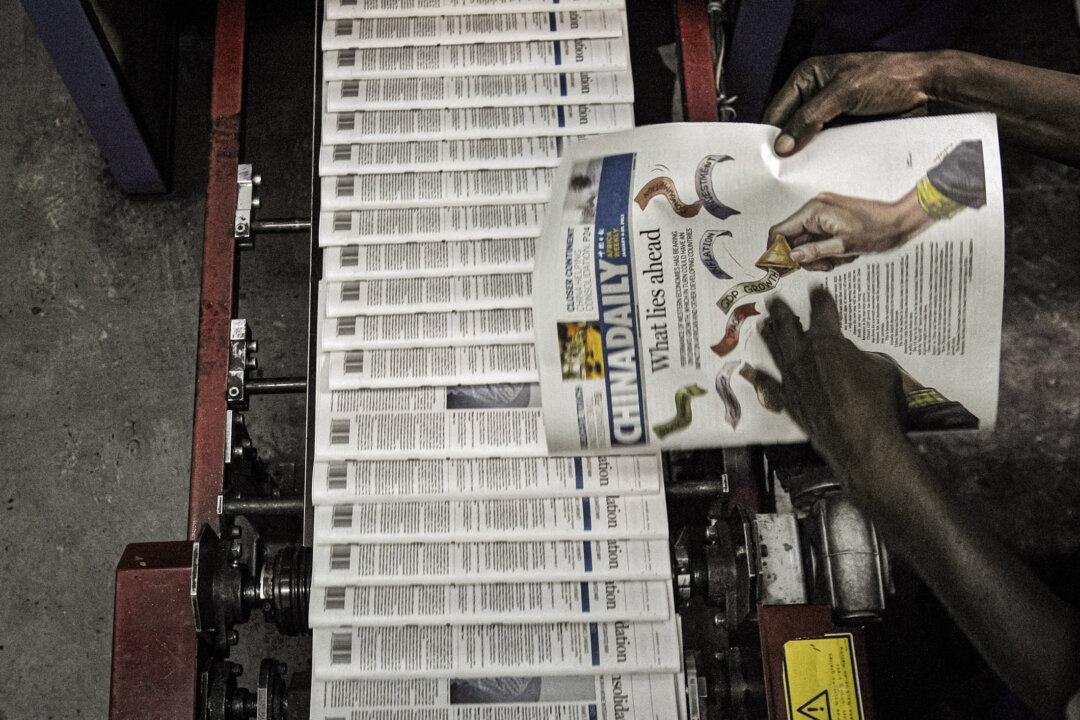 A technician inspects copies of Chinese owned newspaper, China Daily at the printing press in Nairobi, Kenya, in December 2013. (Tony Karumba/AFP via Getty Images)