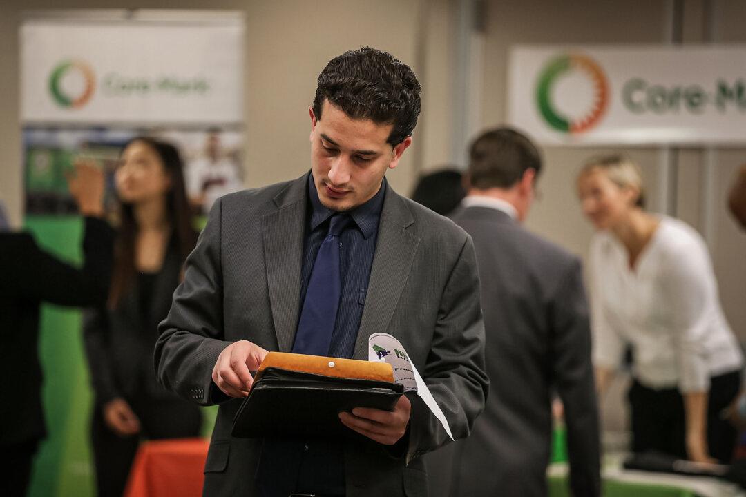 A job seeker prepares to meet with recruiters during a career fair in San Francisco on June 4, 2015. It can take up to eight weeks from submitting an application to receiving an offer, according to Indeed. (Justin Sullivan/Getty Images)