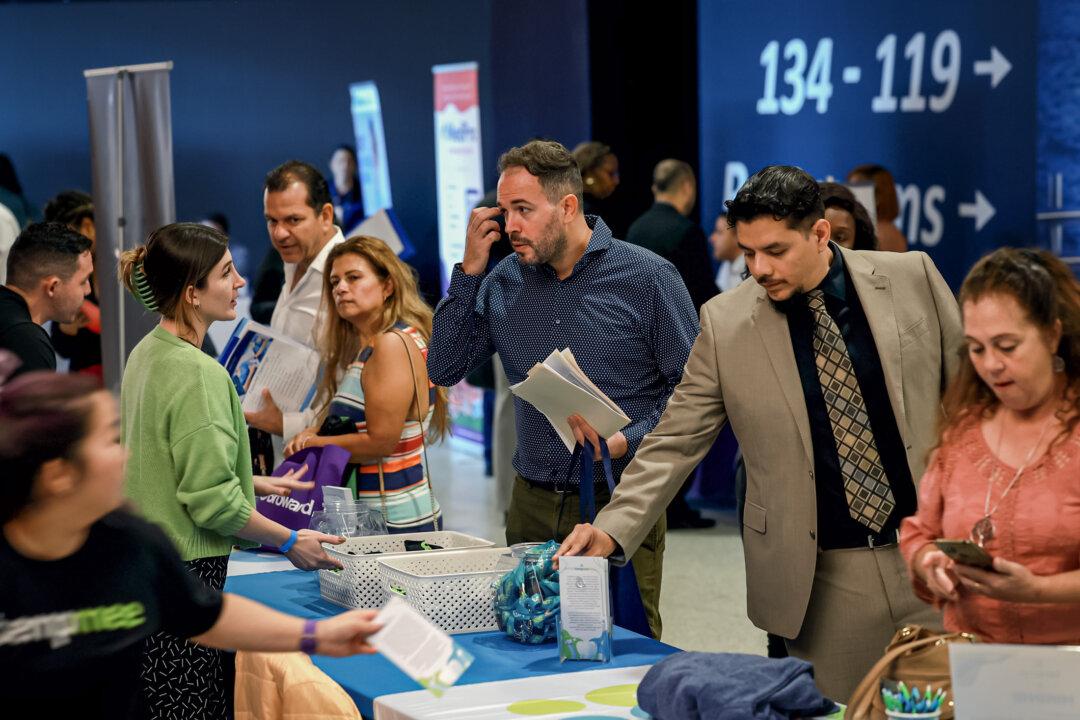 Job seekers converse with recruiters at a job fair in Sunrise, Fla., on Feb. 23, 2023. Hiring managers have admitted to keeping job posts online “just to give the appearance those companies were continually hiring and growing,” according to an HR consultant. (Joe Raedle/Getty Images)