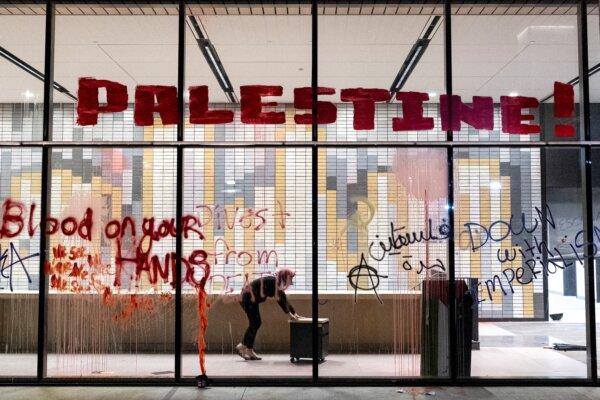 A pro-Palestinian protester pushes a small office cabinet to be used in a makeshift barricade around the California State University–Los Angeles Student Services Building in Los Angeles on June 12, 2024. (Etienne Laurent/AFP via Getty Images)