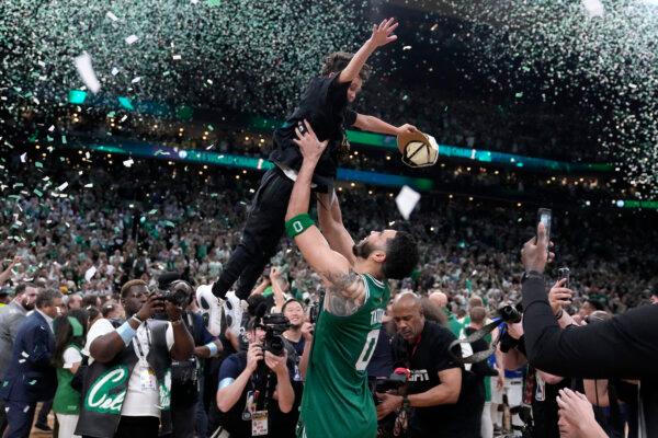 Jayson Tatum lifts his son, Deuce, while celebrating after the Celtics won the NBA championship over the Mavericks in Boston on June 17, 2024. (Charles Krupa/AP Photo)