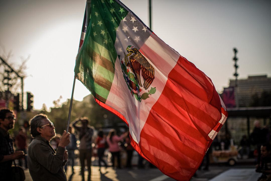 A man carries a U.S. flag and Mexican flag at a rally in Los Angeles on May 1, 2019. Latinos are now the largest minority group in the United States. (David McNew/Getty Images)