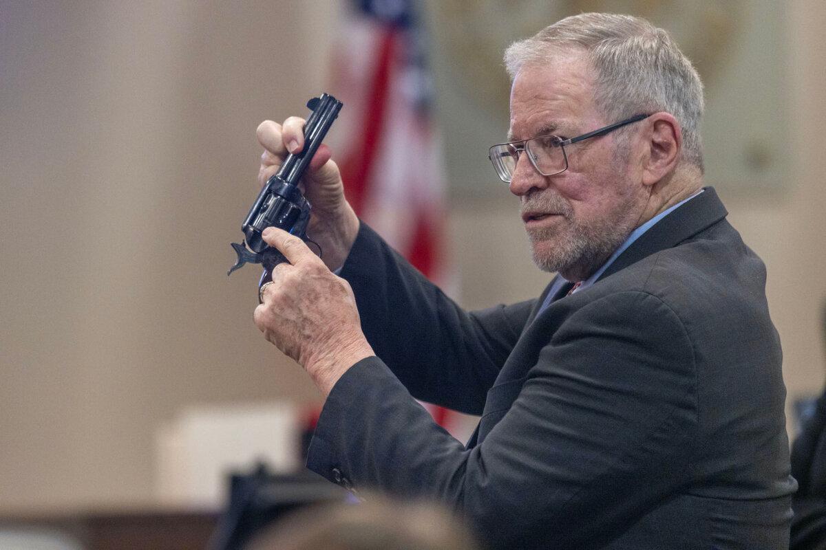 Lucien Haag, forensic science firearms evidence examination and shooting reconstruction expert witness, shows the jury a gun exactly like the evidence gun during the involuntary manslaughter trial of Hannah Gutierrez-Reed at the First Judicial District Courthouse in Santa Fe, N.M., on Feb. 27, 2024. (Sánchez Saturno-Pool/Getty Images)