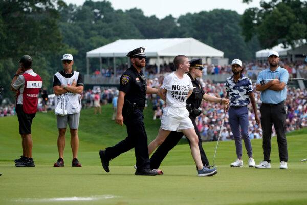 One of several protesters is led away after they ran onto the course during the final round of the Travelers Championship in Cromwell, Conn., on June 23, 2024. (Seth Wenig/AP Photo)