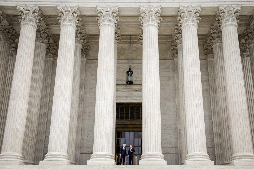 Supreme Court Justice Neil Gorsuch (L) talks with Chief Justice John Roberts by the entrance to the Supreme Court following his official investiture, in Washington on June 15, 2017. (Win McNamee/Getty Images)