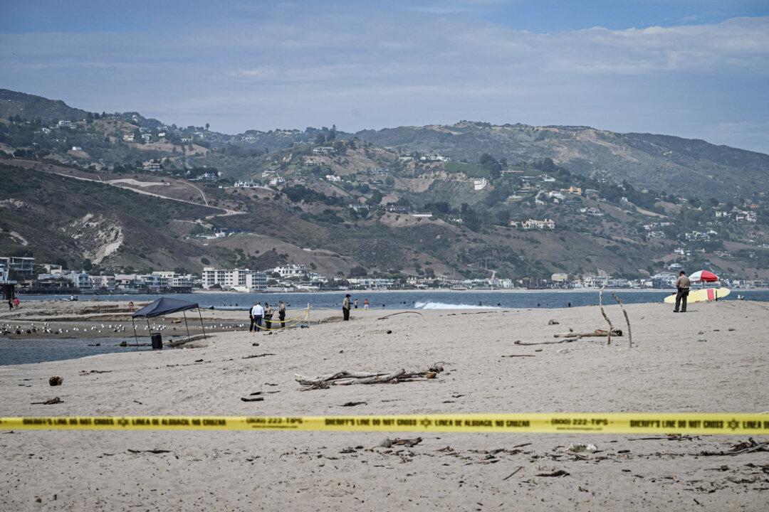 Officials stand next to a barrel where a body was discovered in Malibu Lagoon State Beach, Calif., on July 31, 2023. (Robyn Beck/AFP via Getty Images)