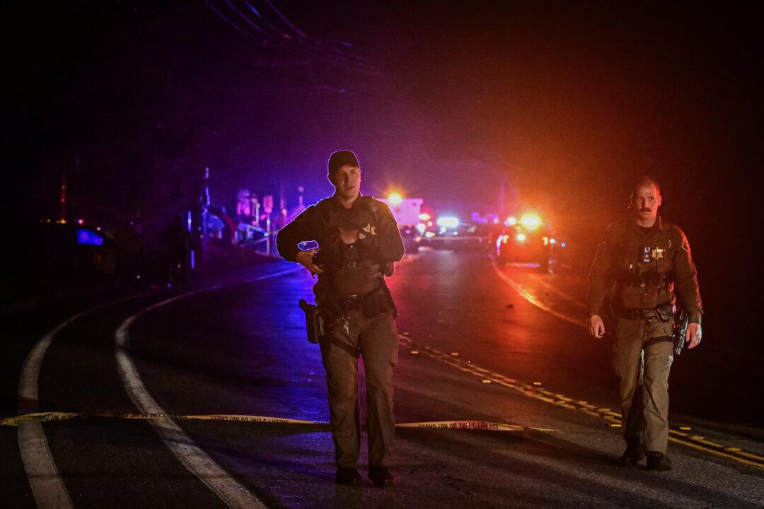 Police officers walk along on a blocked off road after a shooting at a nearby bar in Trabuco Canyon, Calif., on Aug. 23, 2023. (Frederic J. Brown/AFP via Getty Images)