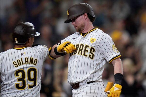 Jake Cronenworth (R) receives congratulations from San Diego Padres teammate Donovan Solano after hitting a home run against the Mariners in San Diego on July 9, 2024. (Gregory Bull/AP Photo)