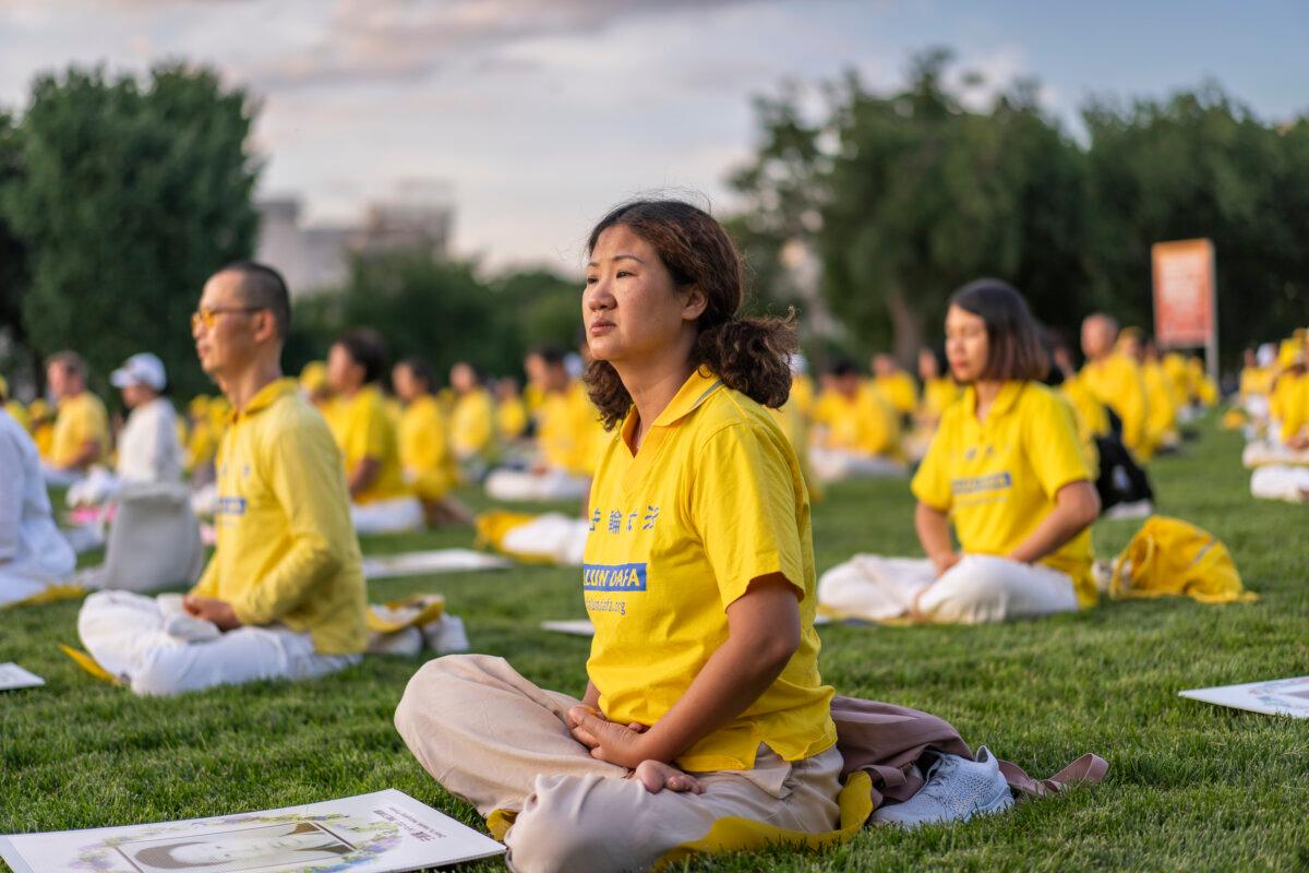 Falun Gong practitioners gather for a candlelight vigil commemorating Falun Gong practitioners’ persecution to death in China by the Chinese Communist Party at the National Mall in Washington on July 11, 2024. (Madalina Vasiliu/The Epoch Times)