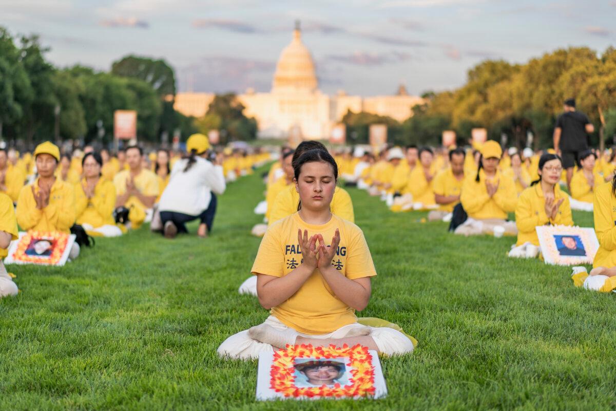 Falun Gong practitioners gather for a candlelight vigil commemorating Falun Gong practitioners’ persecution to death in China by the Chinese Communist Party at the National Mall in Washington on July 11, 2024. (Madalina Vasiliu/The Epoch Times)