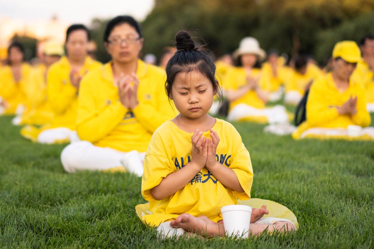 Falun Gong practitioners gather for a candlelight vigil commemorating Falun Gong practitioners’ persecution to death in China by the Chinese Communist Party at the National Mall in Washington on July 11, 2024. (Madalina Vasiliu/The Epoch Times)