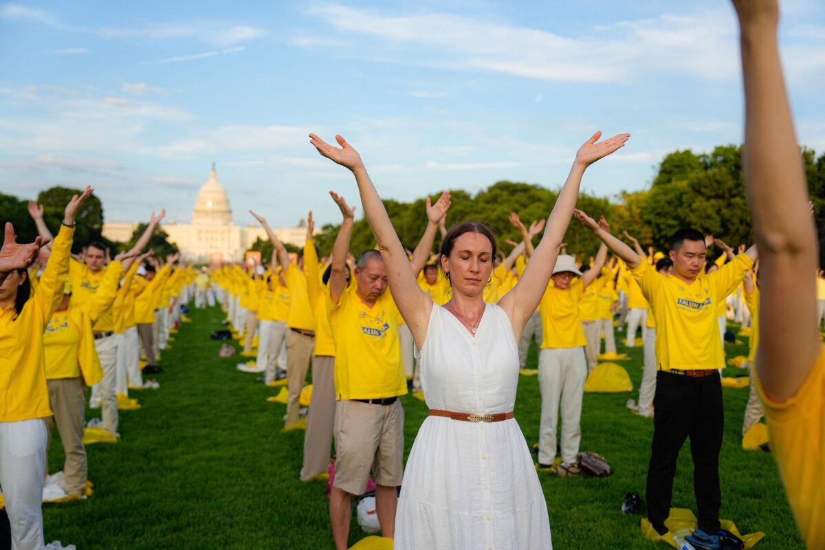 Falun Gong adherents take part in a candlelight vigil in memory of Falun Gong practitioners who passed away during 25 years of ongoing persecution by the Chinese Communist Party in China at the National Mall in Washington on July 11, 2024. (Larry Dye/The Epoch Times)