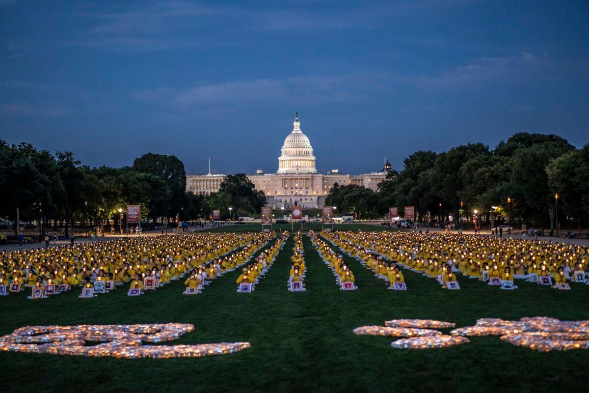 Falun Gong practitioners gather for a candlelight vigil commemorating Falun Gong practitioners’ persecution to death in China by the Chinese Communist Party at the National Mall in Washington on July 11, 2024. (Madalina Vasiliu/The Epoch Times)