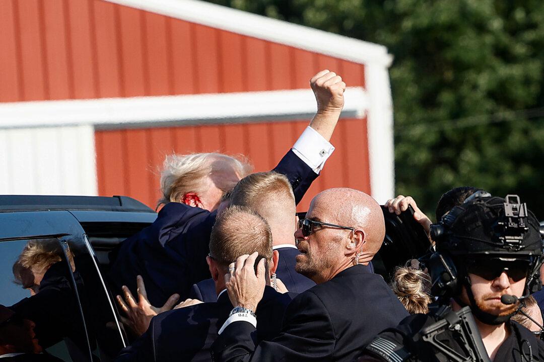 Former President Donald Trump, whose right ear was pierced by one of the bullets, is rushed offstage by U.S. Secret Service agents and escorted into a nearby vehicle. (Anna Moneymaker/Getty Images)