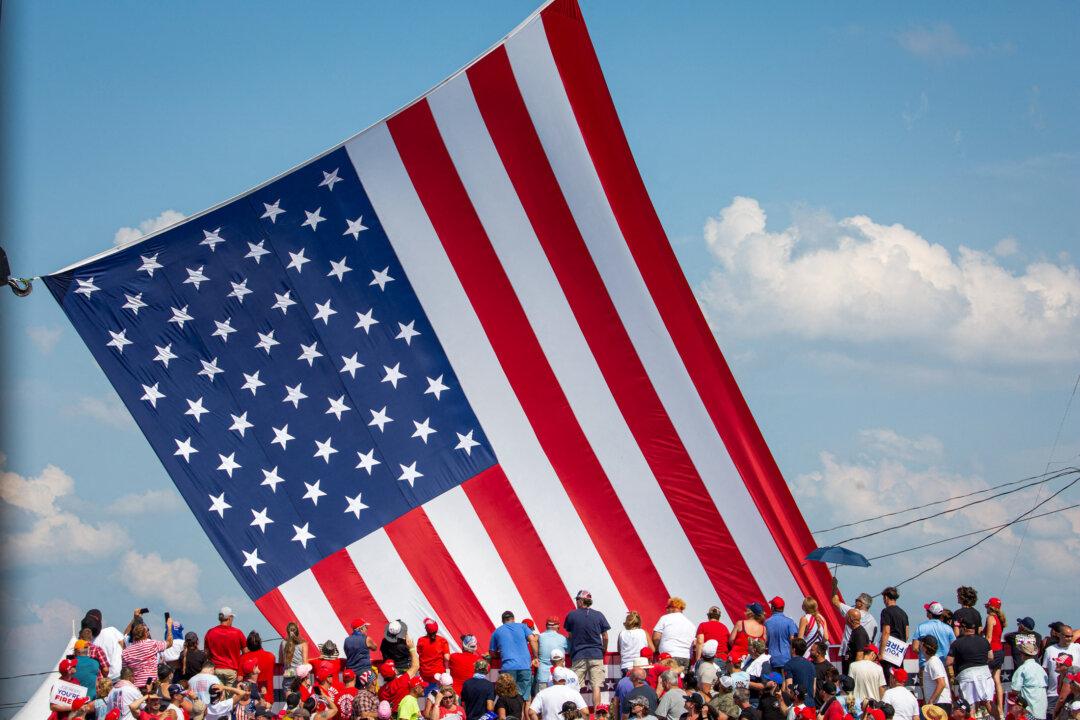 People look at the American flag as it is placed into position at the campaign event in Butler, Penn., on July 13, 2024. (Rebecca Droke/AFP via Getty Images)