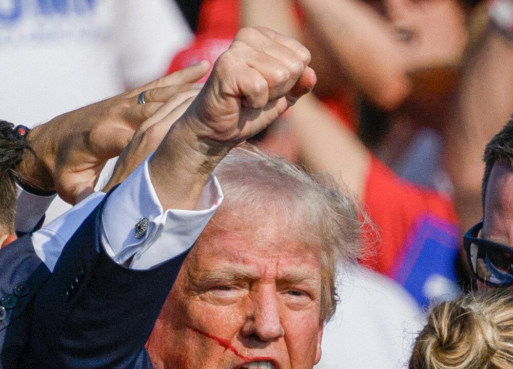 U.S. Secret Service agents rush to protect former President Donald Trump after shots were fired at him. As the former president stands up, he raises his fist to the crowd, and says, “Fight, fight, fight!” (Evan Vucci/AP Photo, Jeff Swensen/Getty Images)