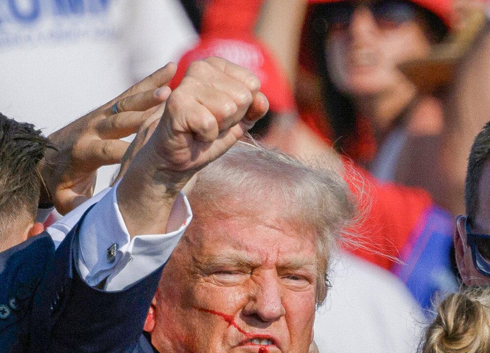 U.S. Secret Service agents rush to protect former President Donald Trump after shots were fired at him. As the former president stands up, he raises his fist to the crowd, and says, “Fight, fight, fight!” (Evan Vucci/AP Photo, Jeff Swensen/Getty Images)