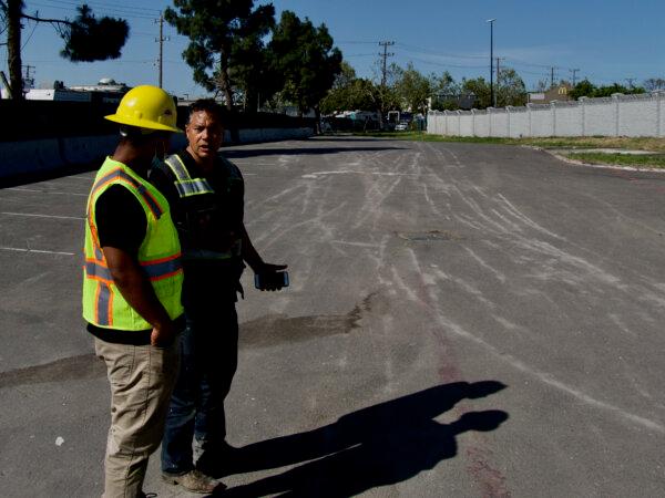 Ken Houston and Emanuel Caprio talk in a lot cleaned out by the Beautification Council on May 2, 2024. (Travis Gillmore/The Epoch Times)