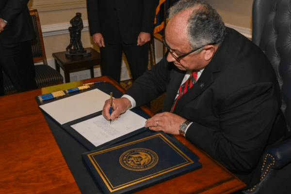 Secretary of the Navy Carlos Del Toro signs two different orders to dismiss the convictions of 256 court-martialed sailors on July 17, 2024. (U.S. Navy photo by Mass Communication Specialist William Bennett IV/Public Domain)