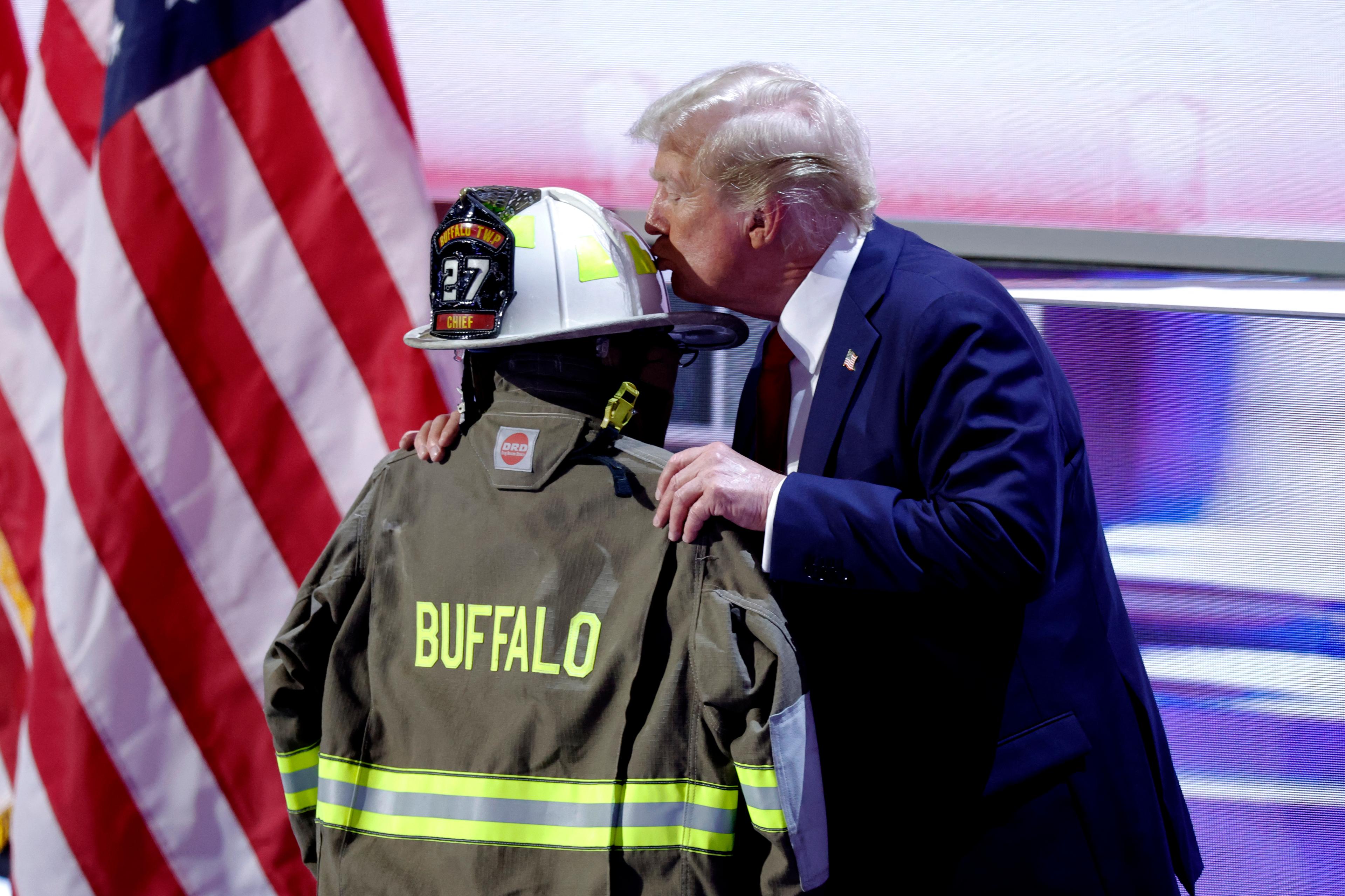 Former president and 2024 Republican presidential candidate Donald Trump kisses a helmet and firefighter's jacket that belonged to Corey Comperatore, who was fatally shot at a rally where Trump survived an assassination attempt, as he accepts his party's nomination on the last day of the 2024 Republican National Convention at the Fiserv Forum in Milwaukee, Wis. on July 18, 2024. (Kamil Krzaczynski/AFP via Getty Images)