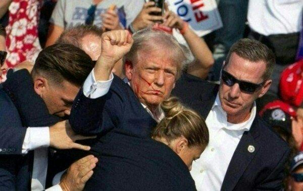 Former President Donald Trump is surrounded by secret service agents as he is taken off the stage at a campaign event at Butler Farm Show Inc. in Butler, Pa., July 13, 2024. (Photo by Rebecca Droker/AFP via Getty Images)