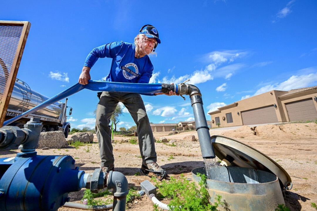 A man delivers water from his truck to a residential water tank in Rio Verde Foothills, Ariz., on Feb. 23, 2023. (Frederic J. Brown/AFP via Getty Images)