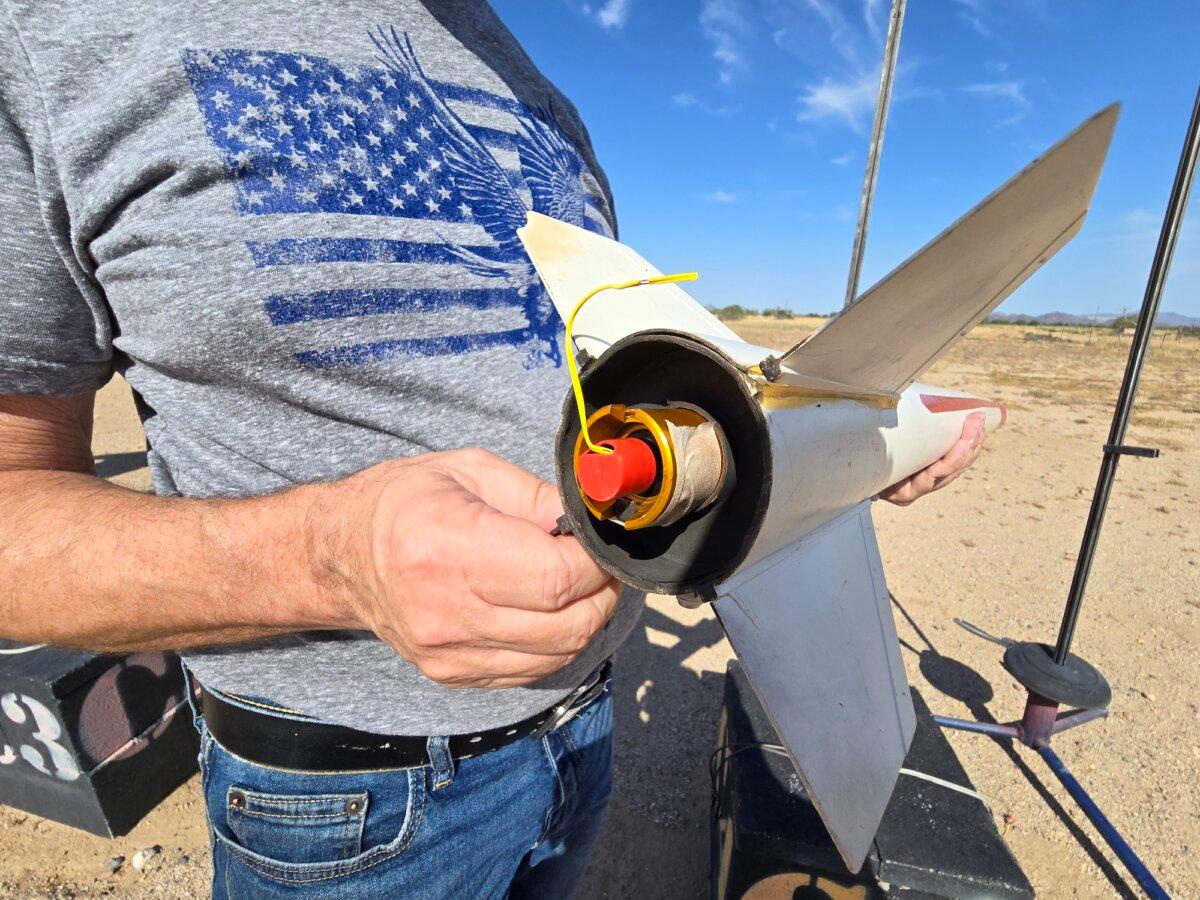 SARA member Dan Pate shows the engine section of his model rocket project in Marana, Ariz., on July 14, 2024. Below, a high-angle view of the rocket before lift-off. (Allan Stein/The Epoch Times)