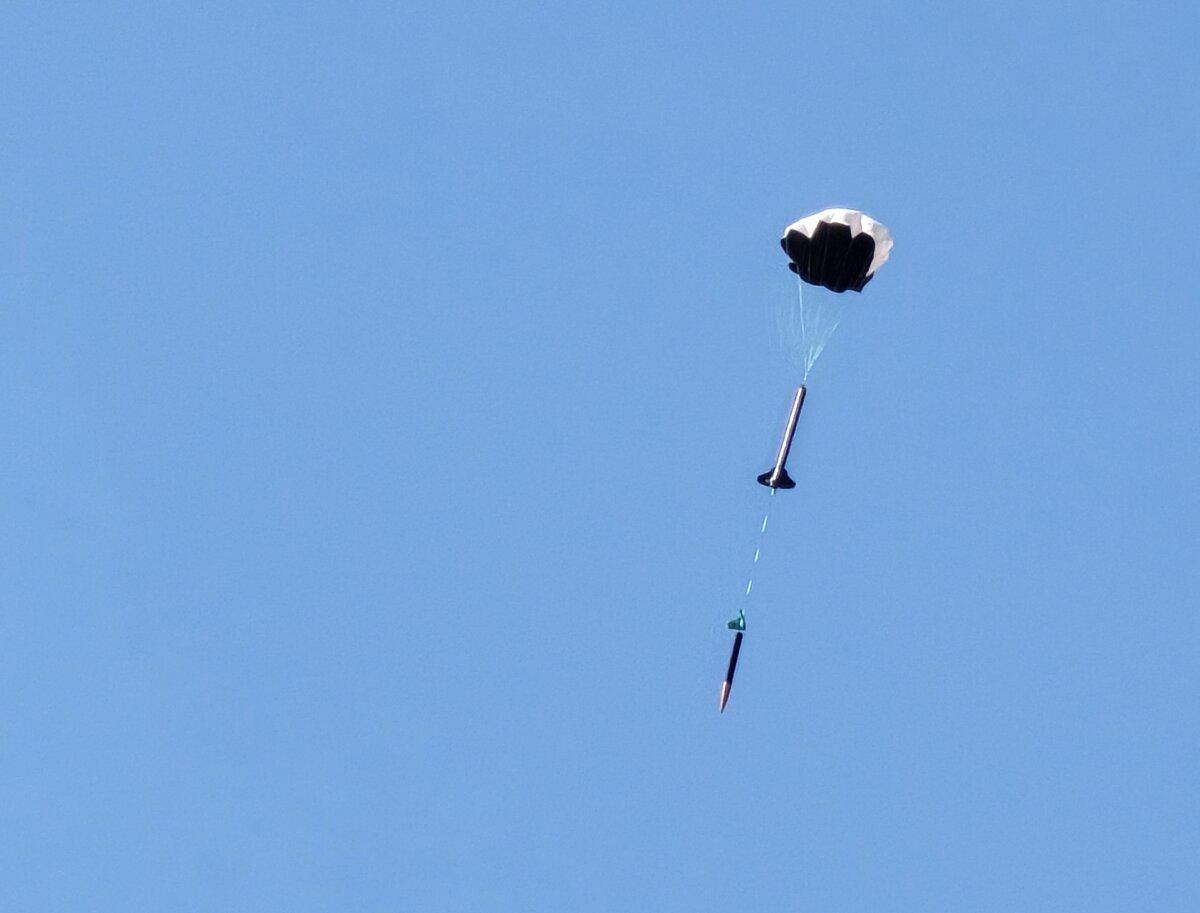 A high-powered rocket prepares for a soft landing with its parachute deployed in southern Arizona on July 14, 2024. (Allan Stein/The Epoch Times)