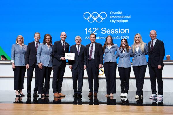 Salt Lake City-Utah 2034 delegation members United States Olympic and Paralympic Committee (USOPC) President Gene Sykes, Fraser Bullock, President & CEO of Salt Lake City-Utah 2034, four time Olympian Catherine Raney-Norman, Utah Governor Spencer Cox, Salt Lake City Mayor Erin Mendenhall, two-time Paralympian Dani Aravich and Olympic Champion Lindsey Vonn poses with International Olympic Committee (IOC) President Thomas Bach as the Salt Lake City-Utah 2034 wins the 2034 Winter Olympic Gam during a IOC Session meeting ahead of the Paris 2024 Olympic Games in Paris on July 24, 2024. (Arturo Holmes/Getty Images)