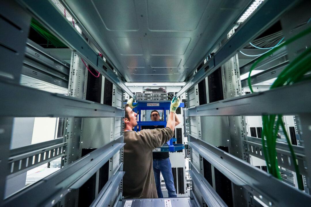 Staff work in the server farm in the 1450 m2 main room of the CERN Data Centre in Meyrin, Switzerland, on April 19, 2017. (Dean Mouhtaropoulos/Getty Images)