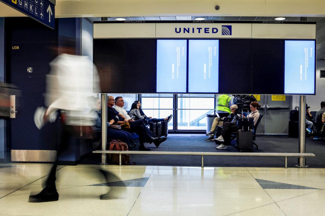 (Top) A screen informs travelers that train information is not available because of the global technical outage, at a subway station in New York City on July 19, 2024. (Bottom) People walk past flight information screens during the outage at Chicago O'Hare International Airport on July 19, 2024. Companies worldwide were affected by an outage from a faulty software update issued by CrowdStrike. (Adam Gray/Getty Images)