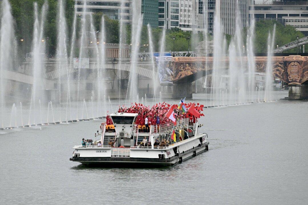 The delegations from Cameroon, Canada, the Central African Republic, Chile, and China sail on a boat during the opening ceremony of the Paris 2024 Olympic Games in Paris on July 26, 2024. (Damien Meyer/AFP via Getty Images)