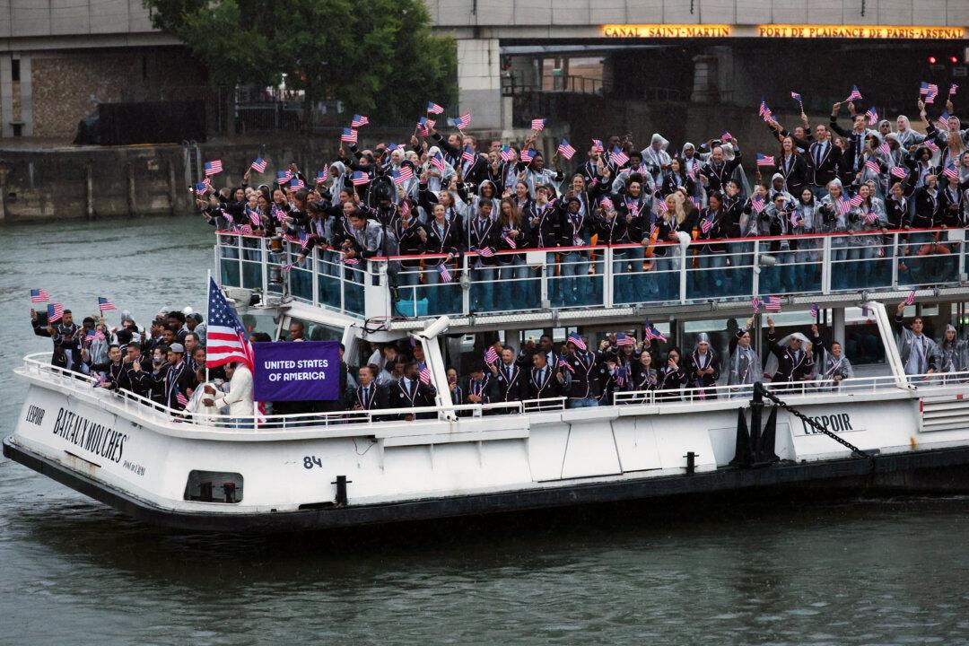 Athletes of Team United States wave flags on the athletes' parade team boat along the River Seine during the opening ceremony of the Olympic Games Paris 2024 in Paris, France, on July 26, 2024. (Jared C. Tilton/Getty Images)