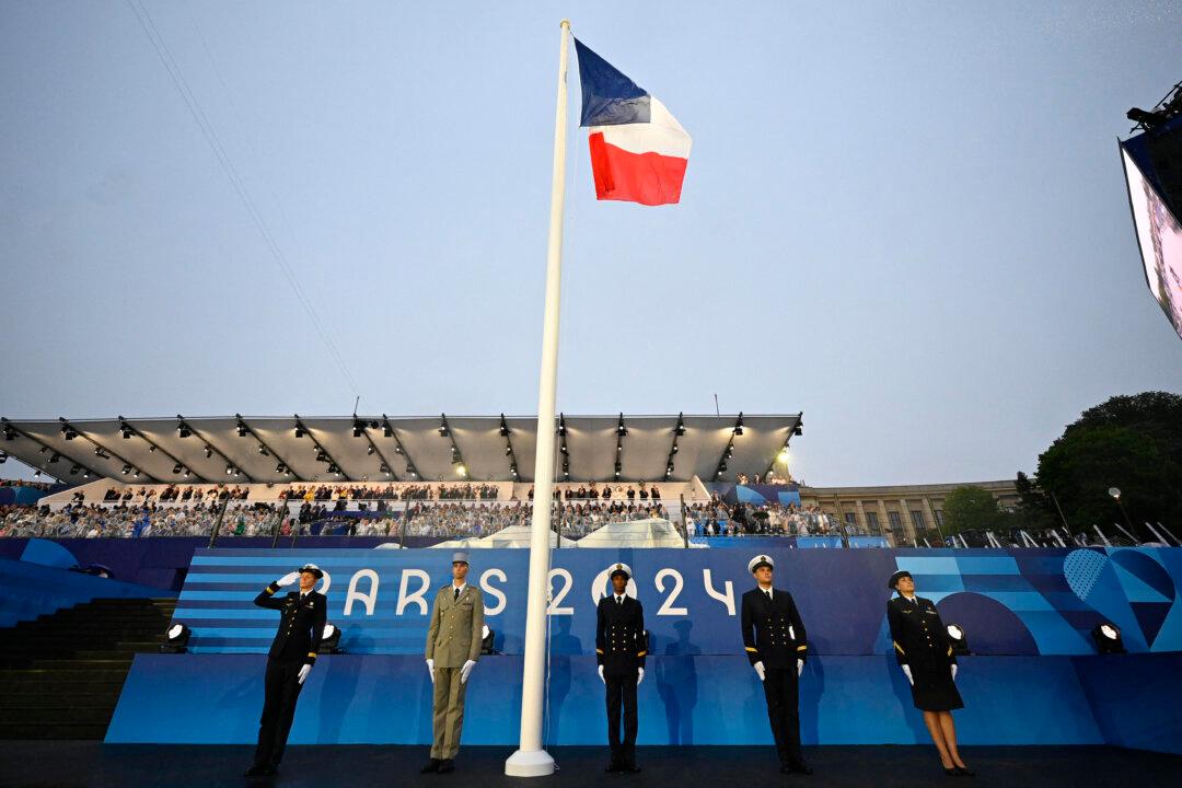 French army officials stand at attention after raising the French flag during the opening ceremony of the Paris 2024 Olympic Games in Paris, on July 26, 2024. (Loic Venance/Pool/AFP via Getty Images)