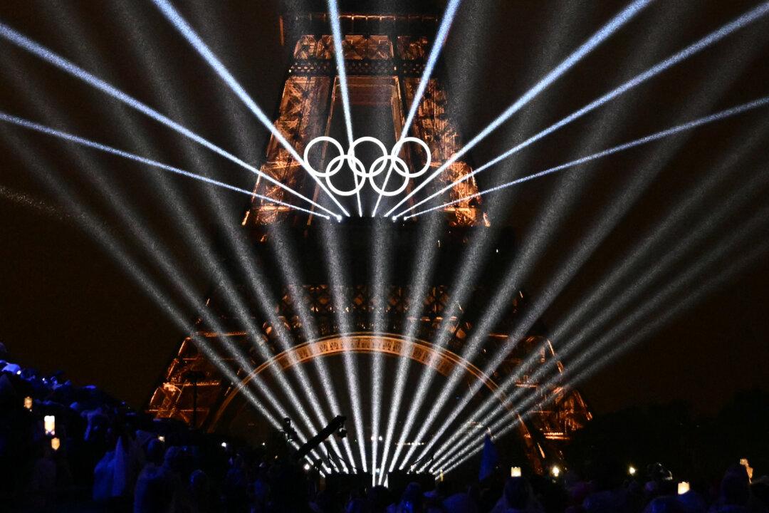 Lights illuminate the Eiffel Tower during the opening ceremony of the Olympic Games in Paris, on July 26, 2024. (Loic Venance/Pool/AFP via Getty Images)