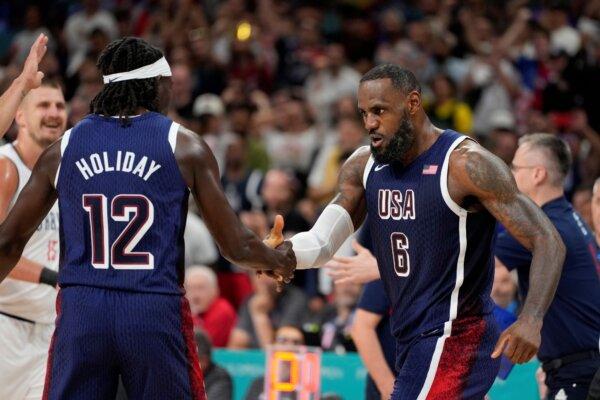 LeBron James (R) celebrates with Team USA teammate Jrue Holiday after scoring against Serbia in a men's basketball game at the Summer Olympics in Villeneuve-d'Ascq, France, on July 28, 2024. (Michael Conroy/AP Photo)