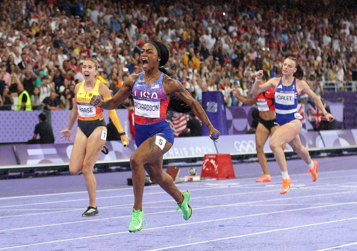 Gold medalist Sha'Carri Richardson of Team United States and bronze medalist Rebekka Haase of Team Germany celebrate as they cross the finish line during the women's 4 x 100-meter relay final on day 14 of the Olympic Games at Stade de France in Paris on Aug. 9, 2024. (Michael Steele/Getty Images)