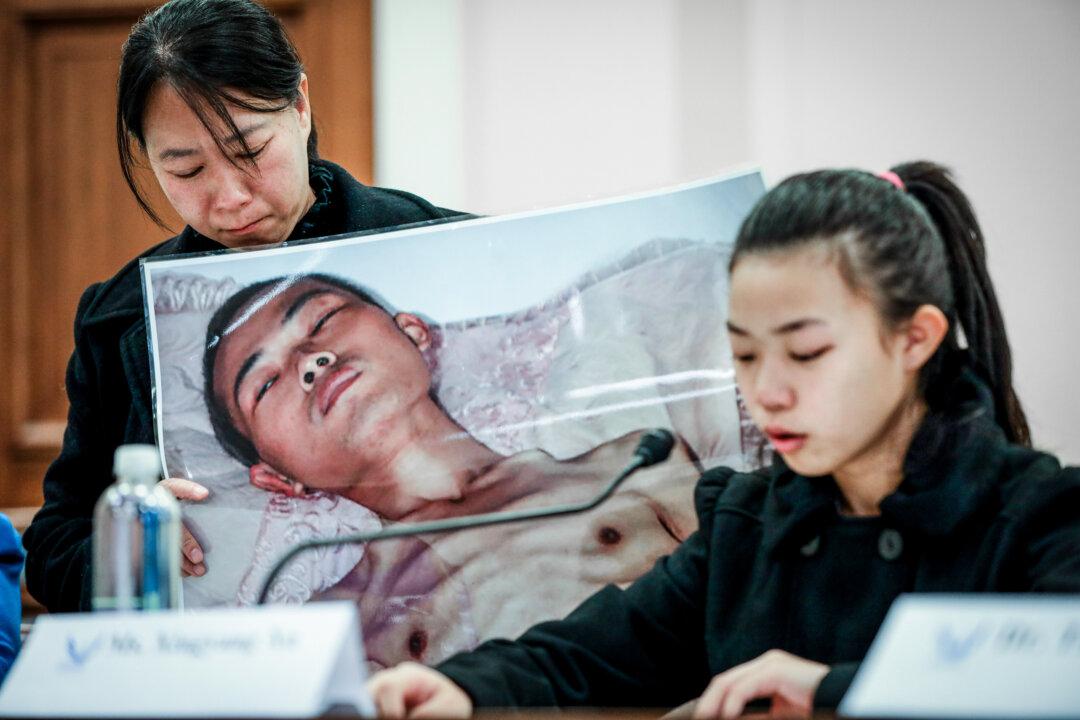 Xu Xinyang (R), a 17-year-old girl whose father (pictured) died as a result of the torture he endured in China because of his belief in Falun Gong, speaks at the “Deteriorating Human Rights and Tuidang Movement in China” forum, next to her mother Chi Lihua at the U.S. Capitol in Washington on Dec. 4, 2018. (Samira Bouaou/The Epoch Times)