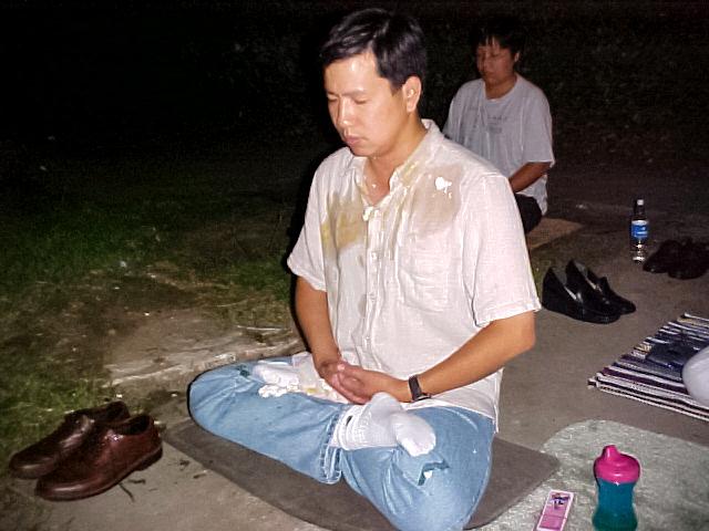 (Left) Sean Yang continues to meditate after eggs were thrown at him from a passing vehicle, in front of the Chinese consulate in Houston in 2002. (Right) The Chinese consulate in Houston. (Minghui.org, Mark Felix /AFP via Getty Images)