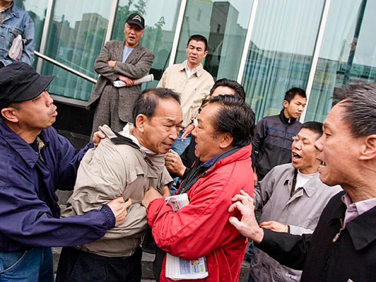 Flushing resident Edmond Erh is allegedly assaulted by a pro-CCP mob while supporting a booth for quitting the Chinese Communist Party, in the Flushing, New York City, on July 10, 2008. (Dayin Chen/The Epoch Times)